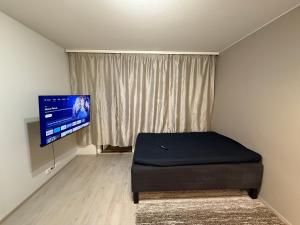 Un dormitorio con una cama y un televisor de pantalla plana. en Sonoramexi, en Tampere