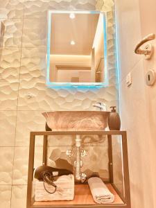 um banheiro com uma pia e um espelho em The Corfu Urban Stays em Ágios Rókkos mais 52 fotografias