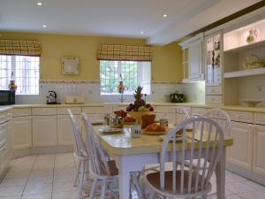 a kitchen with a table and chairs and a kitchen with yellow walls at The Wain House in Chirk +20 photos
