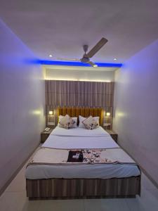 a bedroom with a large bed with a blue ceiling at Hotel Wellingten in Mumbai +61 photos