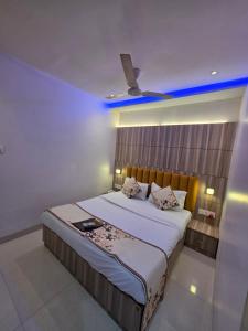 a bedroom with a large bed with a blue ceiling at Hotel Wellingten in Mumbai