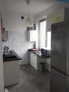 une petite cuisine avec un réfrigérateur et un évier dans l'établissement Kawalerka, à Gdynia 3 autres photos
