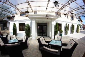 a group of chairs and tables in front of a building at Hotel Goya Collection in Târgu Jiu