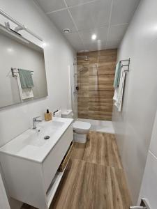 un bagno con un lavandino bianco e un water di Ático costa de la luz a Conil de la Frontera