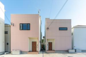 a pink building with two doors in the middle at Grandioso Onna 7-D - Vacation STAY 13349v in Atsutabaru