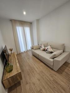 un soggiorno con un divano e un tavolo di Ático costa de la luz a Conil de la Frontera