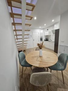 una sala da pranzo con tavolo e sedie in legno di Ático costa de la luz a Conil de la Frontera