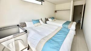 two twin beds in a room with a window at Grandioso Onna 7-D - Vacation STAY 10524v in Atsutabaru +39 photos