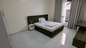 a bedroom with a bed in a room with a window at KIGALI NICE Apartment in Kigali