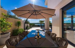 een tafel met een parasol op een terras bij Villa Sense in Posedarje