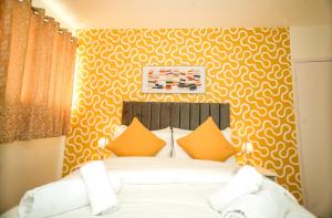 a bedroom with a white bed with orange pillows at Windsor and Heathrow Stay Comfort & Free Parking in Slough