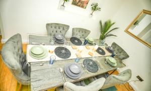 a dining room table with chairs and plates on it at Windsor and Heathrow Stay Comfort & Free Parking in Slough +23 photos