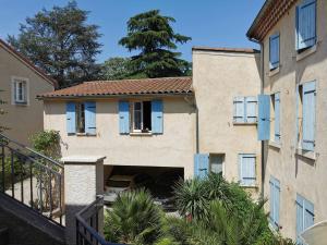 une maison avec des volets bleus et une cour dans l'établissement 10 Charmant studio proche gare et centre, à Valence