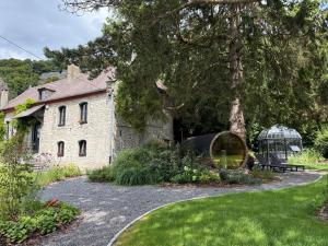 an old stone house with a tree and a garden at gite-abicyclette in Yvoir