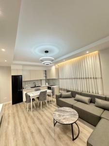 a living room with a couch and a table at Apartment in Kamëz