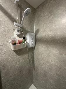 a shower in a bathroom with a phone on the wall at City centre studio in Hull