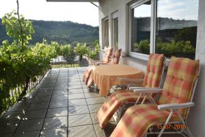 a patio with a table and chairs on a balcony at Ferienweingut Borens in Wiltingen