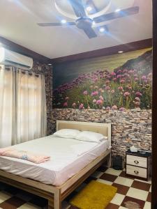 a bedroom with a painting of flowers on the wall at Hotel ViceRoy in Butwāl