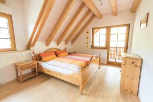 Un dormitorio con una cama en una habitación con techos de madera. en Haus Sattelgrund, en Münstertal