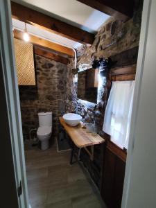 a stone bathroom with a sink and a toilet at La aldea de lug in Rozagás