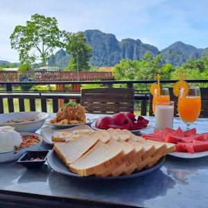 Una mesa con muchos platos de comida encima. en Sichaluenkham vangvieng HOTEL, en Vang Vieng