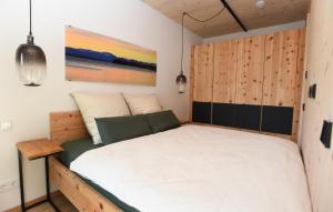 Un dormitorio con una cama con cabecero de madera. en Das SeeQuartier - Ein Ort zum Genießen - Luxuriös und BrandNEU, en Seeshaupt