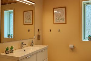 un baño con lavabo y espejo en Havhuset I Øster Hurup - i byen, ved stranden, en Øster Hurup 14 fotos más