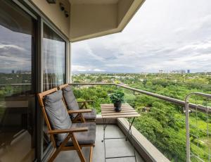 a balcony with a chair and a table at Dominiks Comfort and silent Studio Tambuli Balcony Pool Mactan Ocean View High Floor in Lapu Lapu City