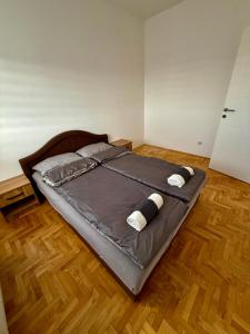 een groot bed in een kamer met een houten vloer bij Romansa in Bijeljina