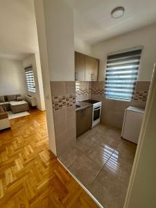 een grote keuken met houten vloeren en een grote kamer bij Romansa in Bijeljina