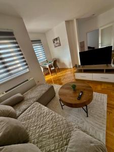 een woonkamer met een bank en een salontafel bij Romansa in Bijeljina