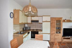a kitchen with white cabinets and a table and a clock at Ferienweingut Borens in Wiltingen