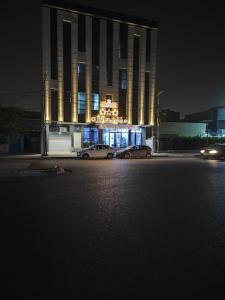two cars parked in front of a building at night at Danzha Motel Erbil in Erbil