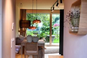sala de estar con mesa y puerta corredera de cristal en Das SeeQuartier - Ein Ort zum Genießen - Luxuriös und BrandNEU, en Seeshaupt