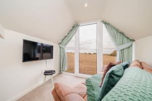 a living room with a couch and a large window at The Annex @ 3 East Town Cottages in West Ashton