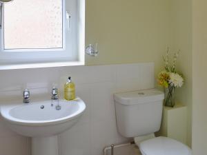 Un baño blanco con inodoro y lavabo. en Upper Floors At The Lawns, en Filey