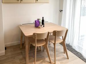 Una mesa de madera con dos sillas y una botella de vino. en Upper Floors At The Lawns, en Filey
