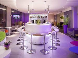 a restaurant with a table and stools in a room at ibis Styles Montbéliard in Montbéliard