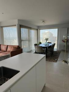a kitchen and living room with a table and chairs at Spacious and modern apartment with open sea view in Ostend