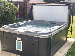 a hot tub in the backyard of a house at Dune Cottage in Caister-on-Sea +9 photos