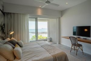 Un dormitorio con una cama grande y una ventana grande en Beachfront apartment with exceptional lagoon view, en Grand Baie 42 fotos más