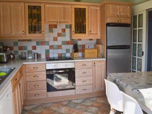 ChelmortonにあるGouldayの木製のキャビネットとコンロ付きオーブンを備えたキッチン