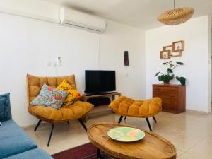 a living room with a couch and a tv at Camel Peak View in Mitzpe Ramon