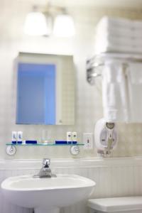 a white bathroom with a sink and a mirror at Pan American Oceanfront Hotel in Wildwood Crest