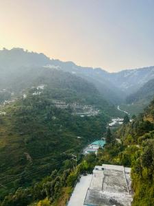 a view of a valley with a mountain at 3 H Homestay in Mussoorie +48 photos
