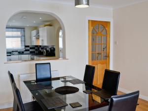a dining room with a table and chairs and a kitchen at Seaview in Oban
