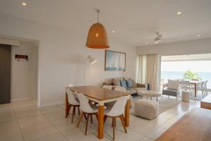 Un comedor y una sala de estar con mesa y sillas. en Beachfront apartment with exceptional lagoon view, en Grand Baie