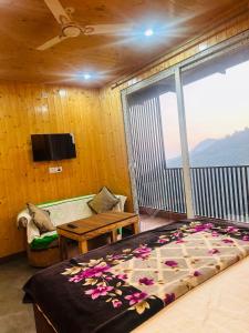 a bedroom with a bed and a balcony with a tv at 3 H Homestay in Mussoorie