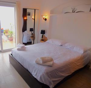 Un dormitorio con una gran cama blanca con toallas. en "Terrasse de la Mer 8" Résidence"Sol y Mar" AC-Wifi-BBQ-Piscine-Pkg, en Begur 118 fotos más