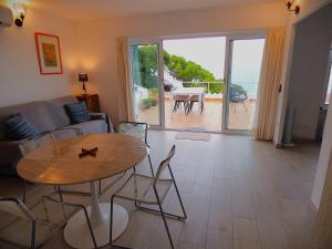 Una sala de estar con una mesa y vista al mar. en "Terrasse de la Mer 8" Résidence"Sol y Mar" AC-Wifi-BBQ-Piscine-Pkg, en Begur